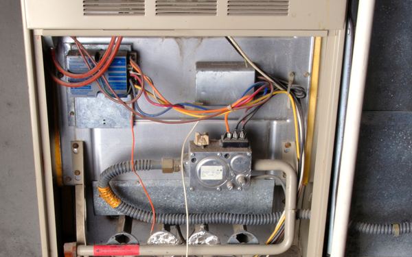 Gas furnace with the access panel off, showing the burners and gas valve
